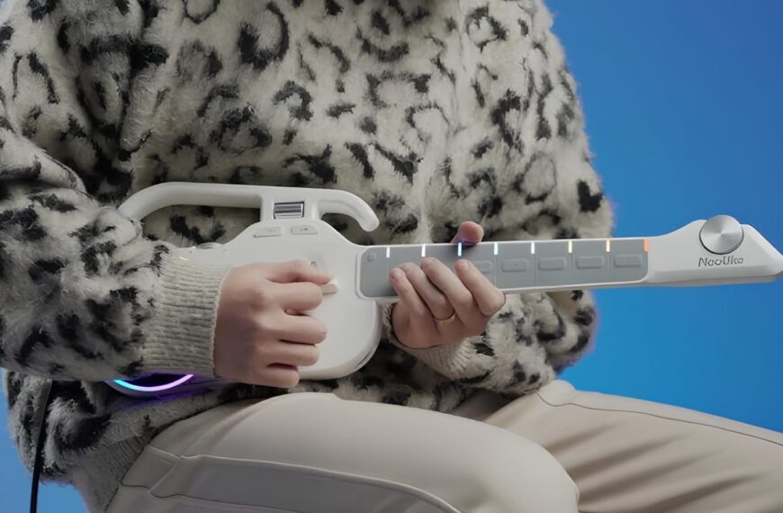 Человек играет на белой музыкальной гитаре на фоне синего цвета.