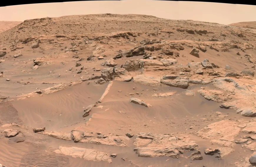 Поверхность Марса с камнями и песчаными дюнами на фоне пустынного ландшафта.