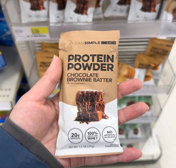 Протеиновый порошок со вкусом шоколадного брауни в руке.