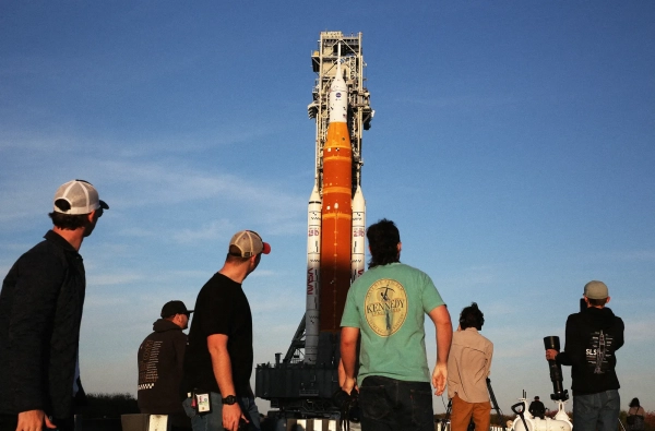 Изображение может содержать: взрослого человека, ракетное оружие, самолет, космический корабль, транспортное средство, одежду (джинсы и брюки).