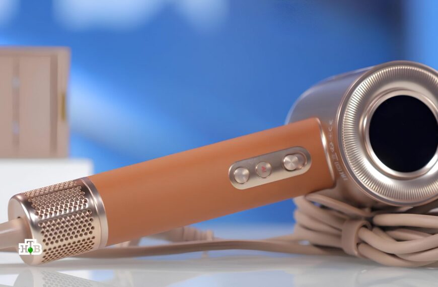 Коричневый фен с кнопками управления на фоне голубого размытого фона.