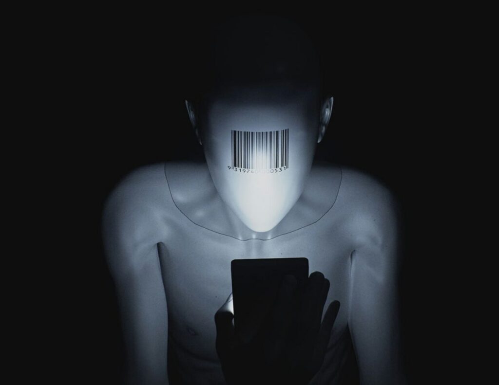 Манекен со штрихкодом на лице смотрит на смартфон в темноте.
