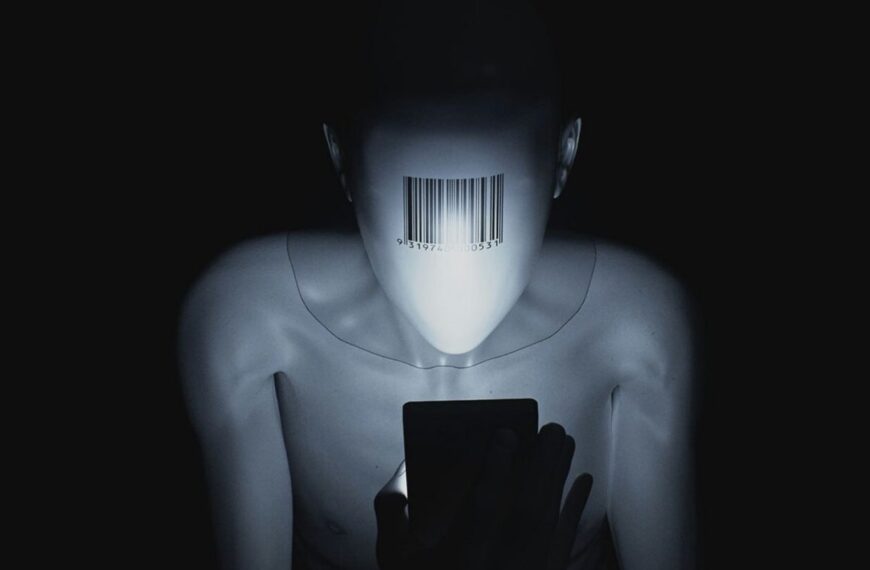 Манекен со штрихкодом на лице смотрит на смартфон в темноте.