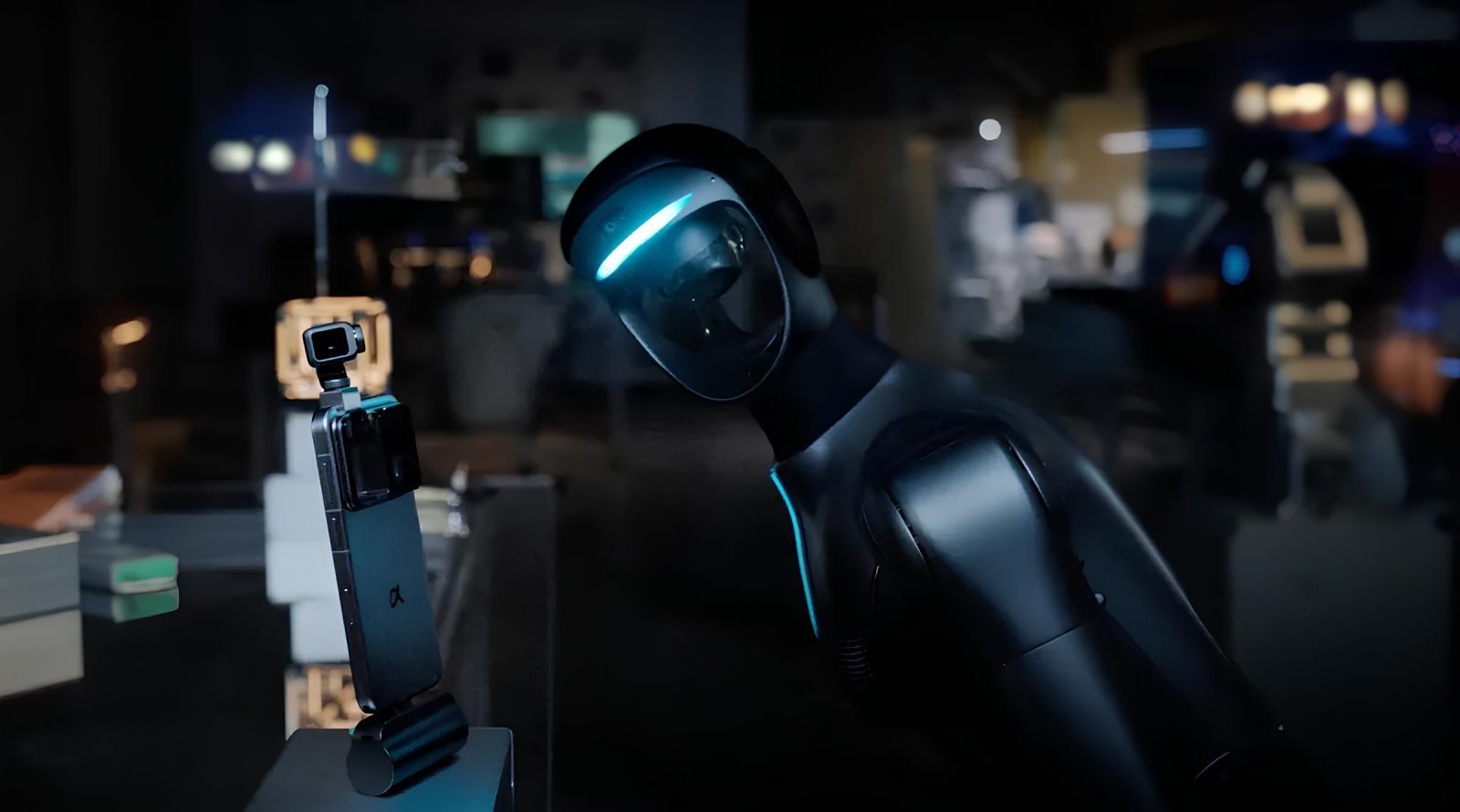 Робот наклоняется к смартфону в тёмной комнате, демонстрируя взаимодействие.