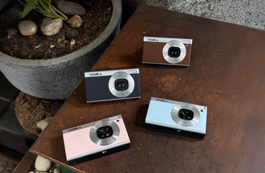 Четыре винтажные камеры Yashica разных цветов на деревянной поверхности.