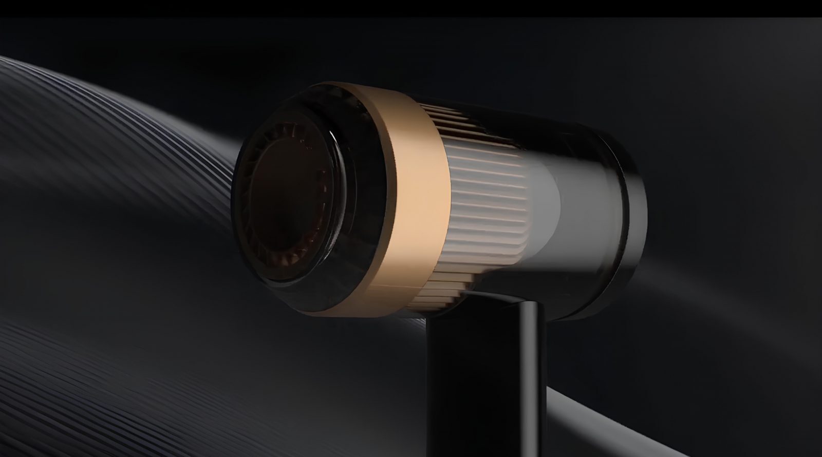 Черно-золотой фен на темном фоне, минималистичный дизайн.