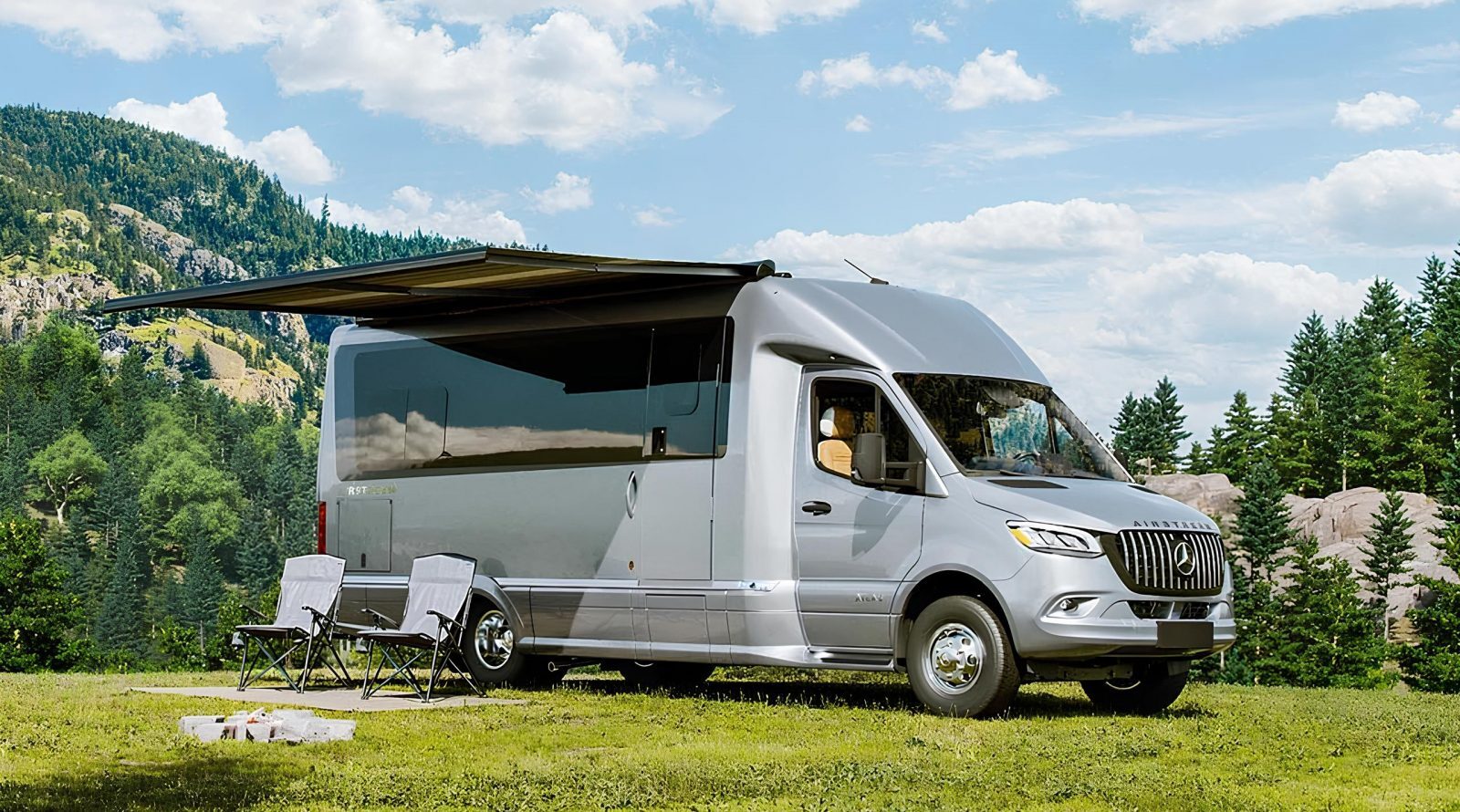 Дом на колесах в лесу с раскладными стульями и выдвижным тентом для кемпинга.