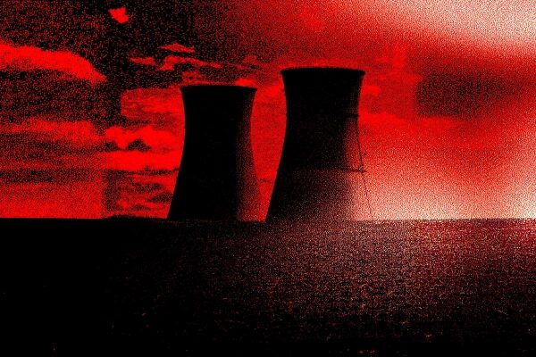 Красные силуэты башен ядерной электростанции на фоне контрастного неба.