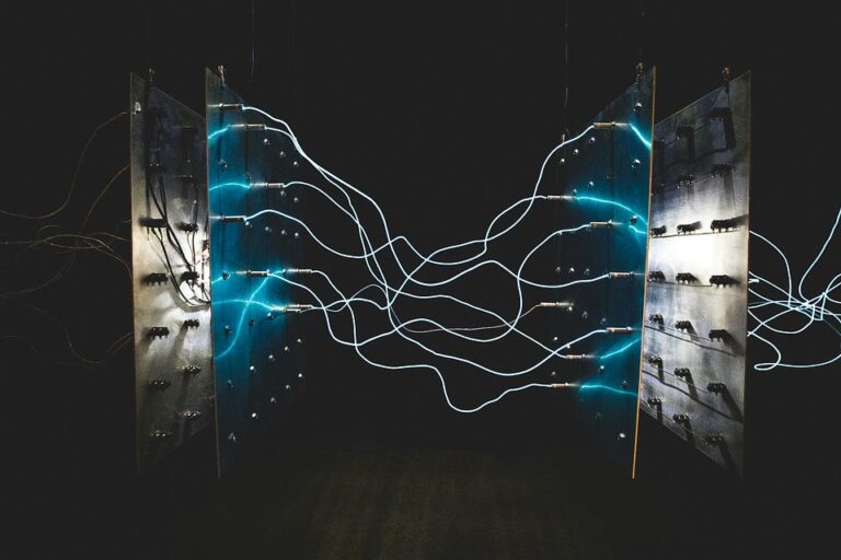 Электрические кабели и световые эффекты между панелями в темном помещении.