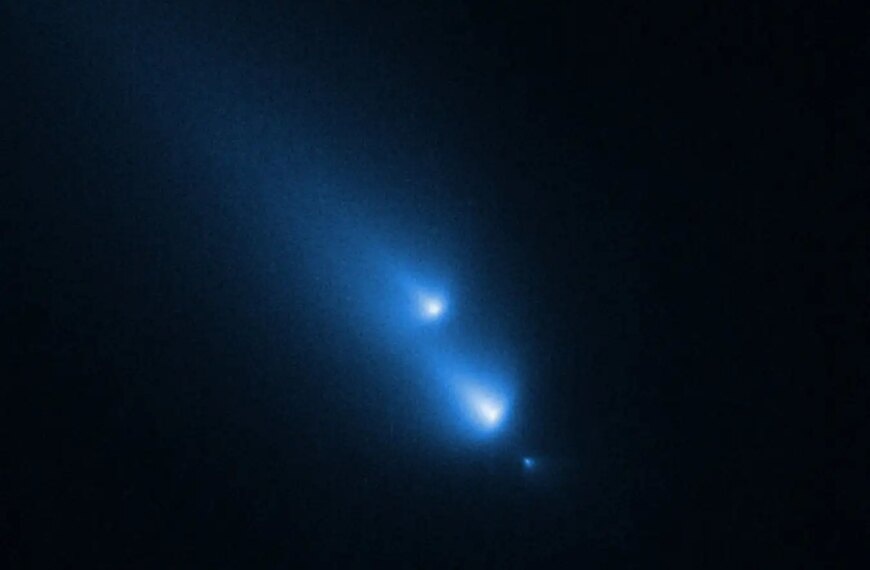 Комета в космосе с ярким синим хвостом и светящимися фрагментами на тёмном фоне.