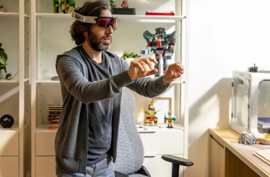 Человек с гарнитурой виртуальной реальности в офисе с полками и игрушками.
