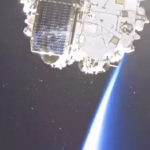 Космический аппарат в открытом космосе, вид Земли с ярким лучом света.