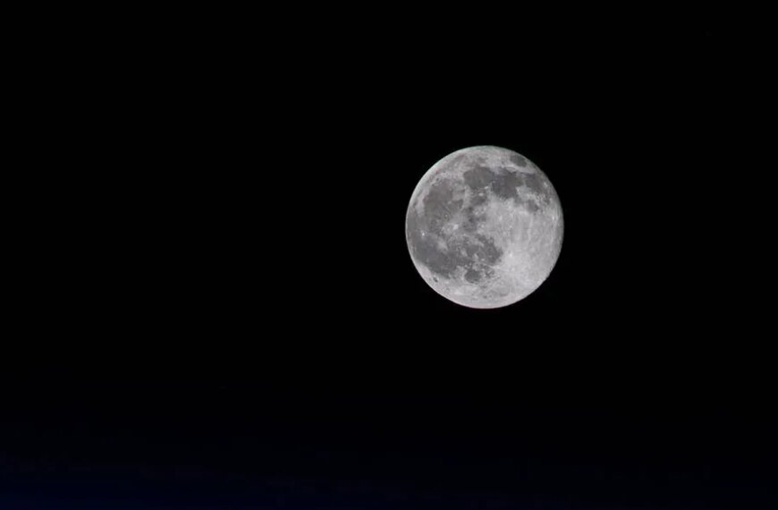Полнолуние на ночном небе, яркий свет Луны в темноте, астрономия и природа.