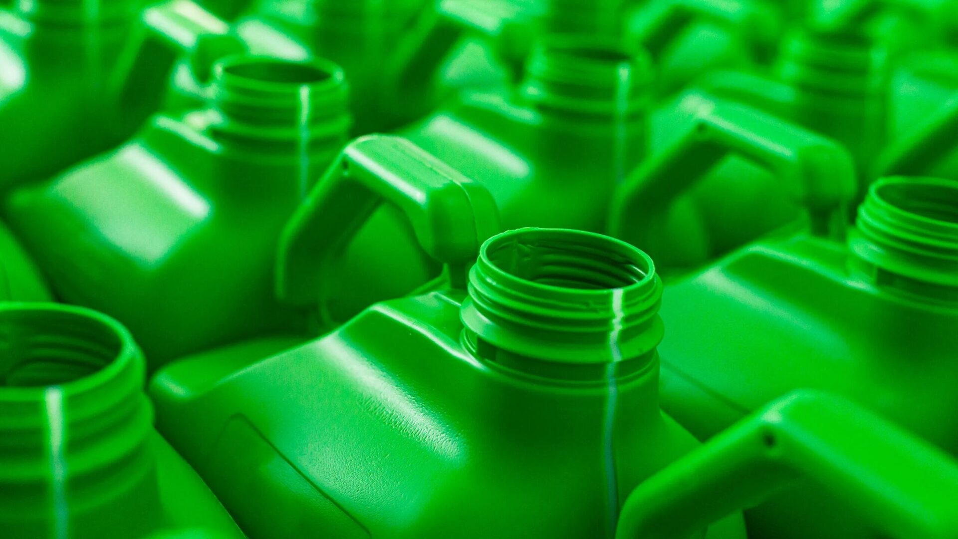 Цены на топливо стремительно растут. Следующим может стать пластик. 1 Крупный план сетки из зеленых пластиковых кувшинов.