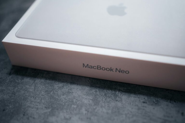 Упаковка MacBook Neo на сером фоне.