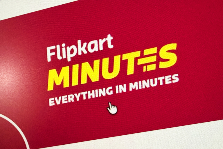 Надпись "Flipkart Minutes" на красном фоне, доставка товаров за минуты.