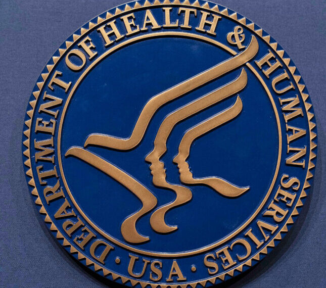 Логотип Департамента здравоохранения и социальных служб США на синем фоне.