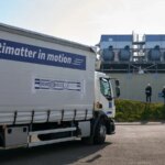 Грузовик с надписью "Antimatter in motion" на заводской территории, антиматерия в движении.