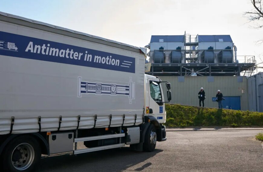 Грузовик с надписью "Antimatter in motion" на заводской территории, антиматерия в движении.