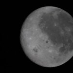 Луна в фазе полнолуния на черном небе, видны кратеры и детали поверхности.