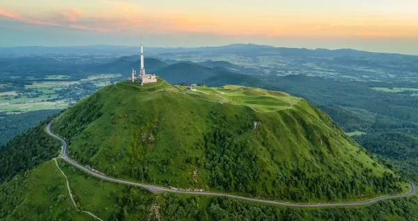 Высокая белая башня на вершине холма.