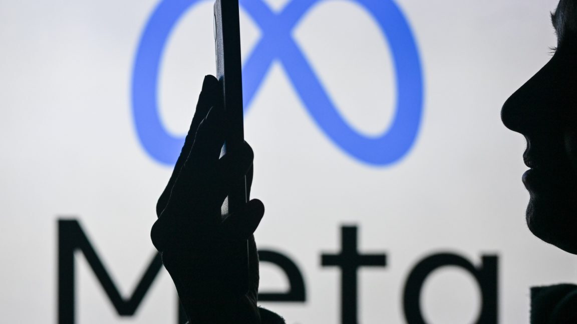 Изображение женщины, держащей мобильный телефон на фоне логотипа Meta, отображаемое на экране компьютера.