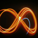 Световая линия в форме бесконечности на тёмном фоне. Абстрактное искусство и энергия.