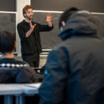 Лектор объясняет материал студентам в университете, классная аудитория.