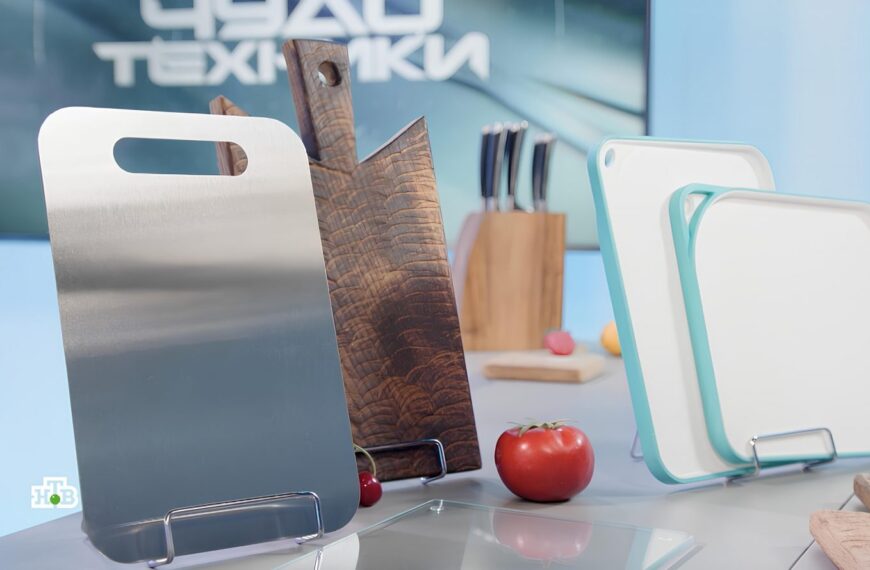 Разнообразные разделочные доски на кухонном столе, рядом помидоры.