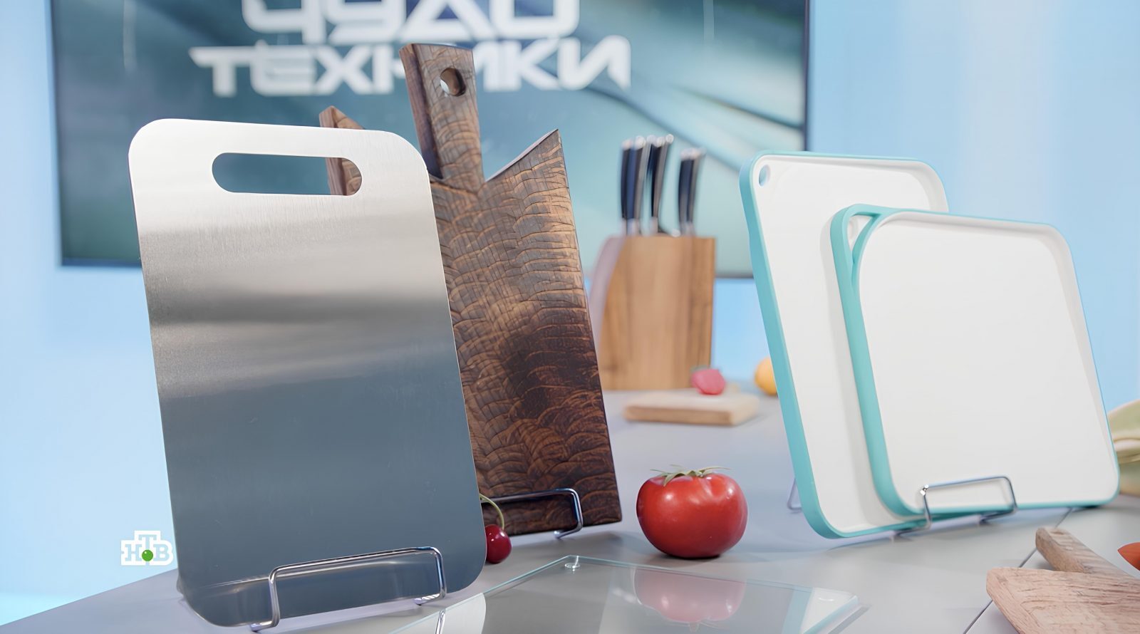 Разнообразные разделочные доски на кухонном столе, рядом помидоры.