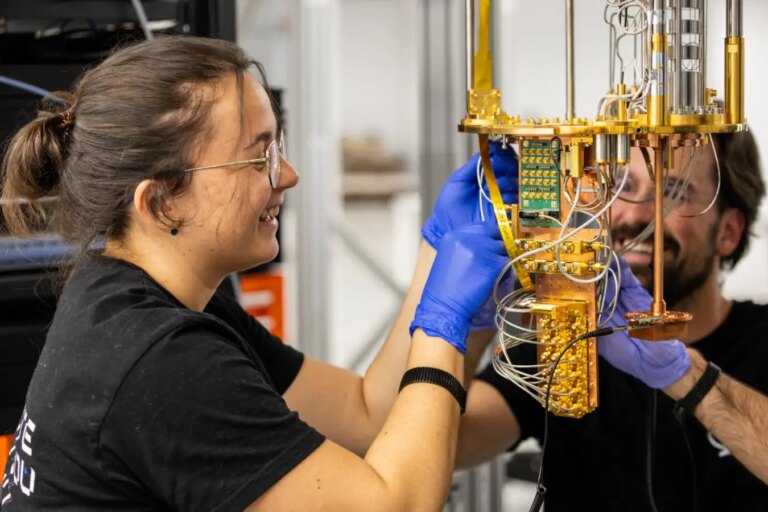 Техники работают над квантовым компьютером в лаборатории, используя высокотехнологичное оборудование.