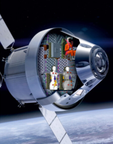 Космический аппарат с манекенами в кабине, летящий над Землей в космосе.