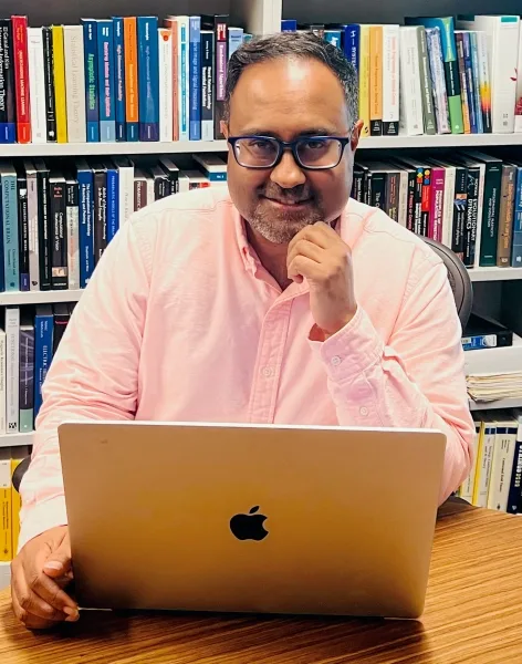 Исследователи раскрыли скрытые составляющие креативности искусственного интеллекта. 3 Мужчина за ноутбуком в библиотеке