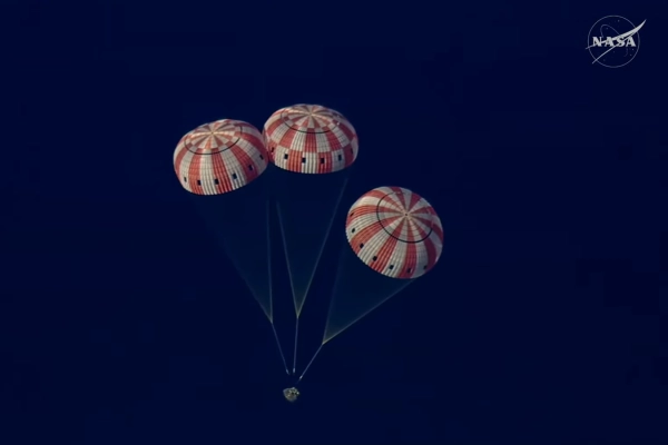 Капсула NASA с тремя парашютами, спускается на Землю, вид сверху.