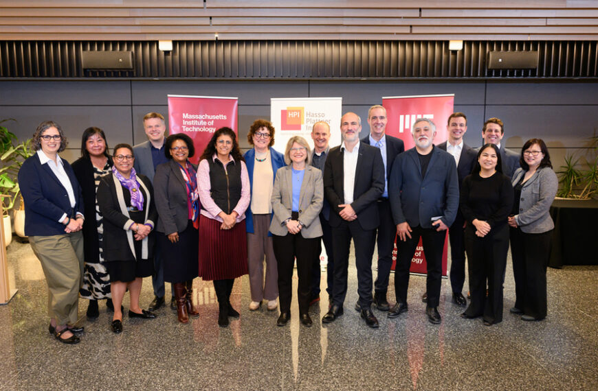 Группа людей перед баннерами MIT и HPI в конференц-зале.