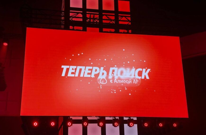 Красный экран с надписью "Теперь поиск с Алисой AI" на мероприятии.