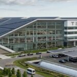 Завод Tesla с солнечными панелями и ветряками, экологически чистое производство автомобилей.