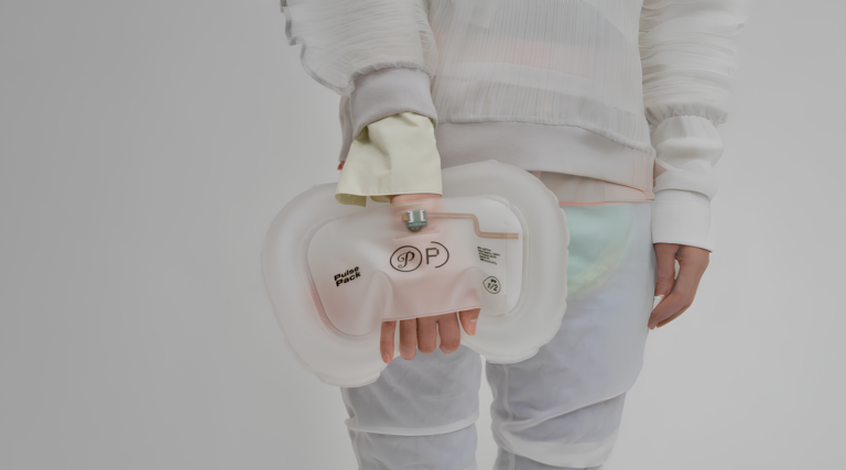 Человек держит инновационную сумку Pulse Pack в современном стильном наряде.