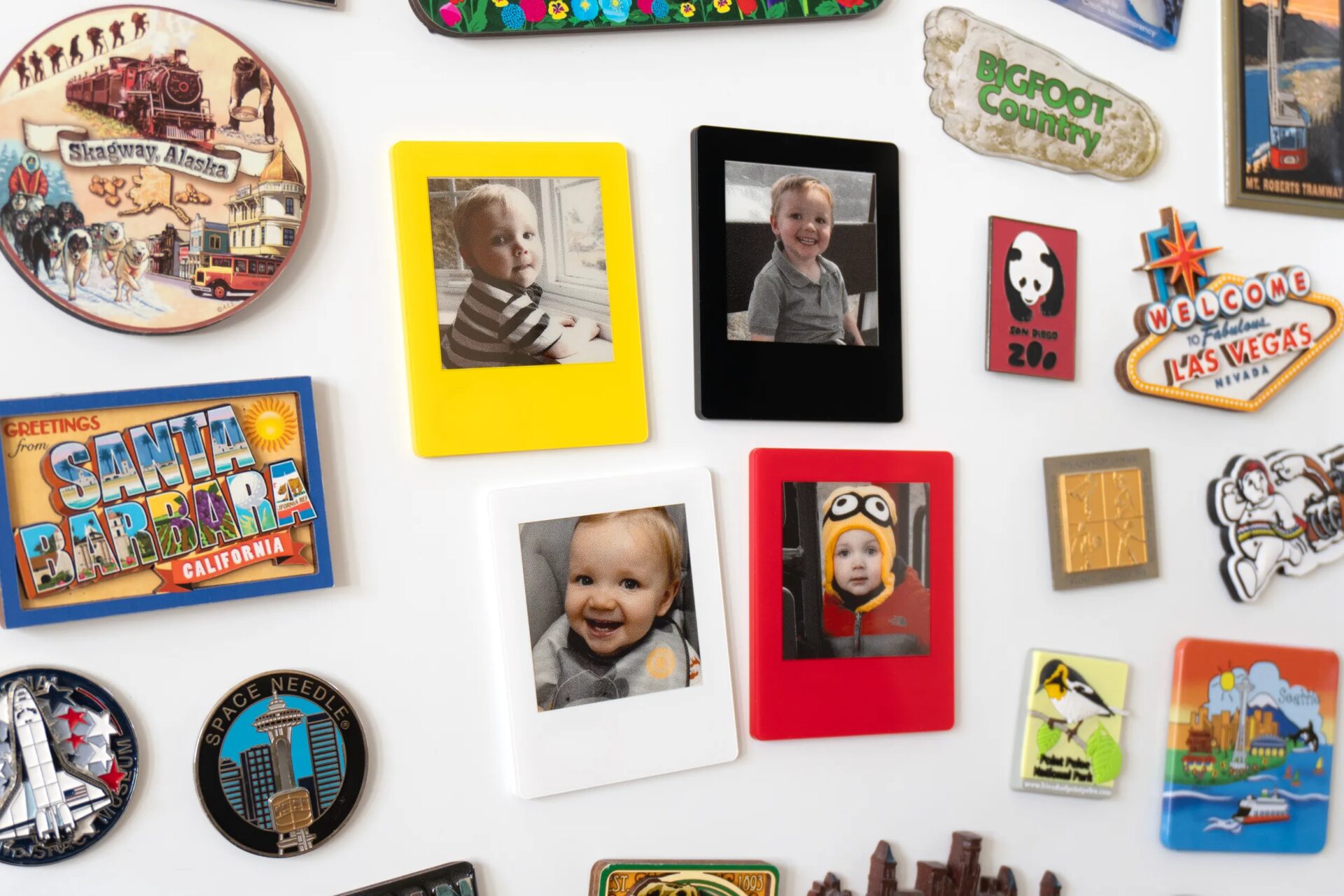 Four VidaBay Snap magnetic photo frames attached to a white board surrounded by magnets.