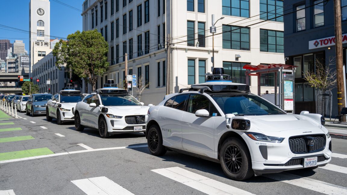 Три беспилотных автомобиля Waymo едут в ряд по городской улице Сан-Франциско, Калифорния, 12 марта 2026 года. (Фото: Smith Collection/Gado/Getty Images)