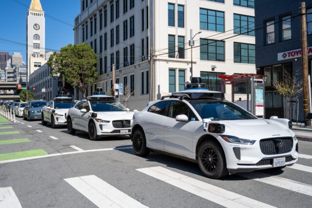 Три беспилотных автомобиля Waymo едут в ряд по городской улице Сан-Франциско, Калифорния, 12 марта 2026 года. (Фото: Smith Collection/Gado/Getty Images)