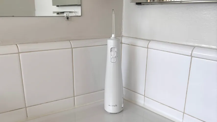 Белый беспроводной ирригатор Waterpik Cordless Pulse 3100 на белой столешнице.