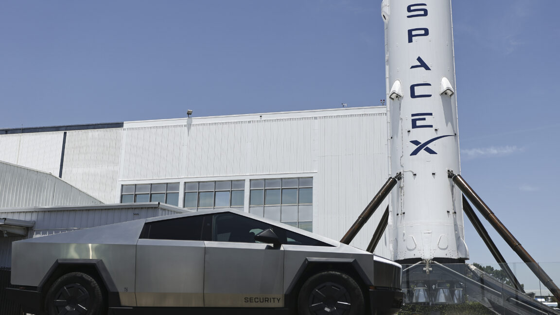 Рекламный щит SpaceX перед зданием компании Space Exploration Technologies Corp. в Хоторне, штат Калифорния, 3 июня 2026 года. На переднем плане стоит Tesla Cybertruck.