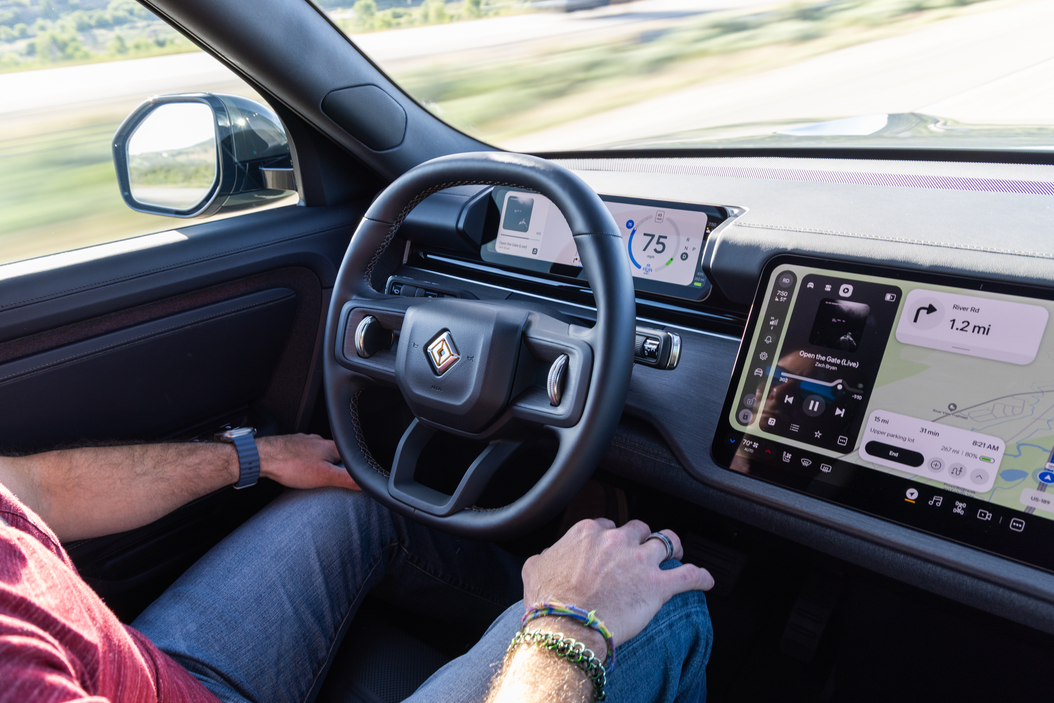 Мужчина сидит за рулем Rivian R2.