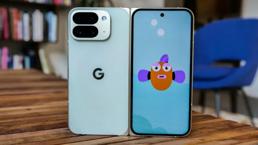 Samsung Galaxy Z Fold 8 Ultra против Google Pixel 10 Pro Fold: сравнение высококлассных складных смартфонов. 6 На фотографии показан разложенный и вертикально стоящий на столе Pixel 10 Pro Fold. Слева — задняя панель телефона, справа — передний экран с изображением рыбы.