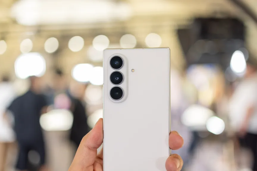 На фоне эффекта боке человек держит в руках Samsung Galaxy Z Fold 8. На снимке видна задняя панель телефона, где расположен блок камер.