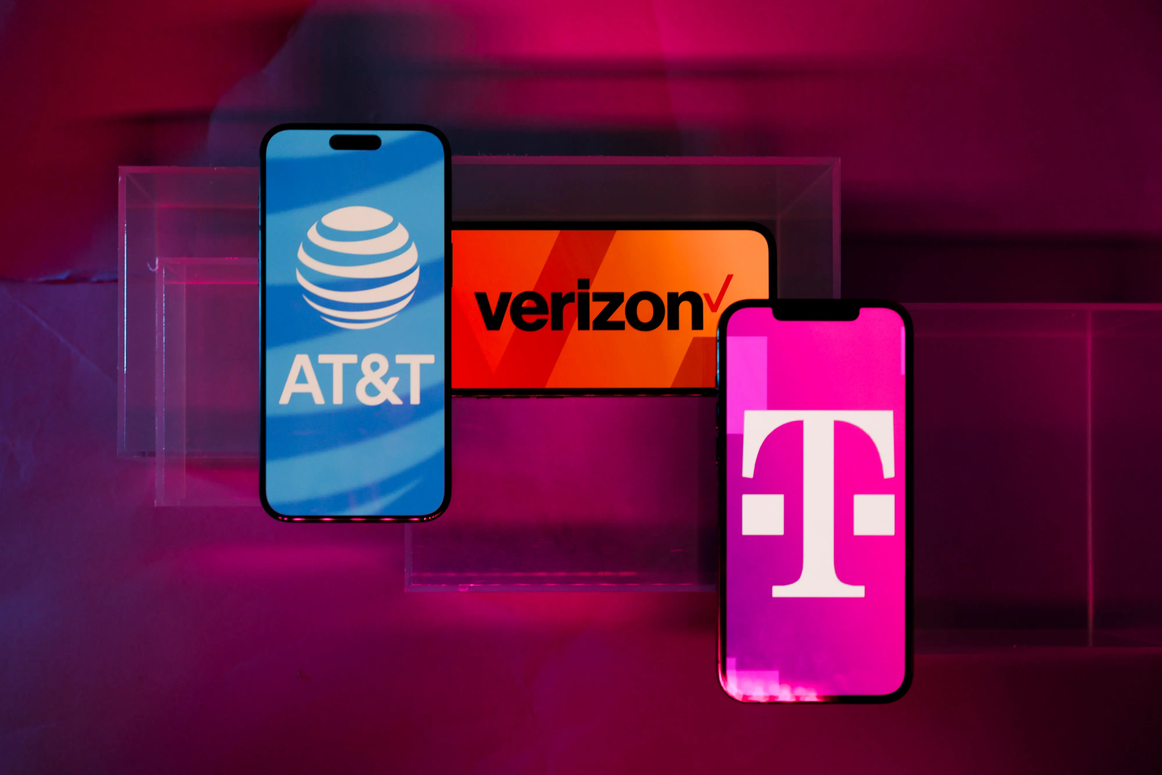 Логотипы Verizon, AT&T и T-Mobile на экранах смартфонов.