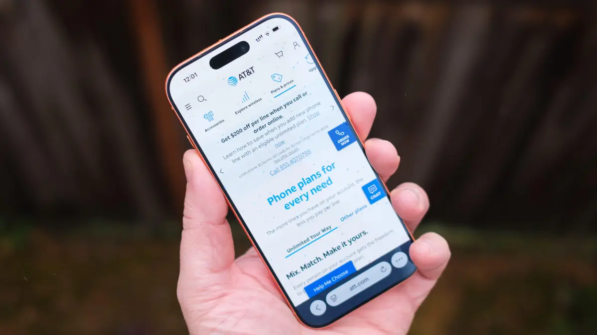 AT&T против Verizon: как выбрать между двумя крупнейшими операторами мобильной связи 7 Рука, держащая iPhone, на экране которого отображаются тарифные планы мобильной связи AT&T.