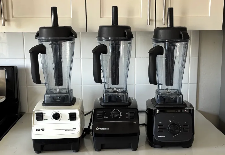 Блендеры Vitamix 5000, 5200 и VX1 на белой столешнице.